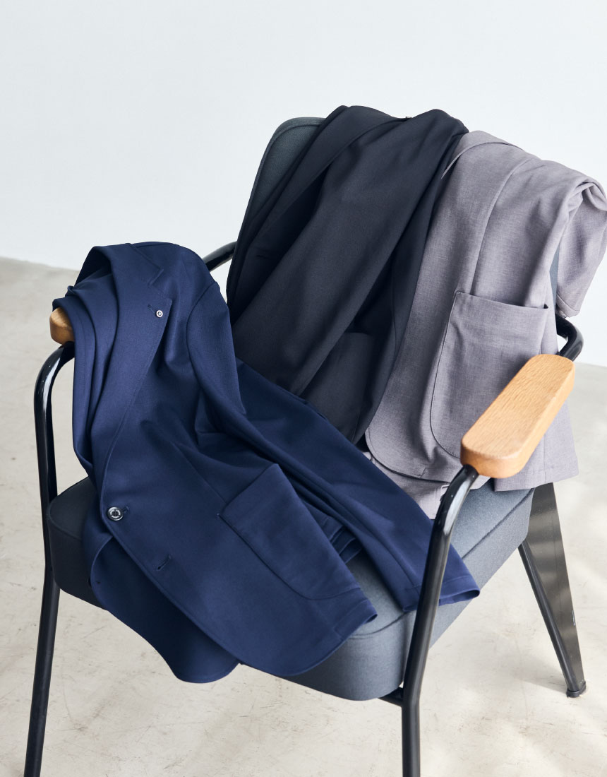 椅子に置かれているライトブラウンのスーツジャケット・ネイビーのスーツジャケット