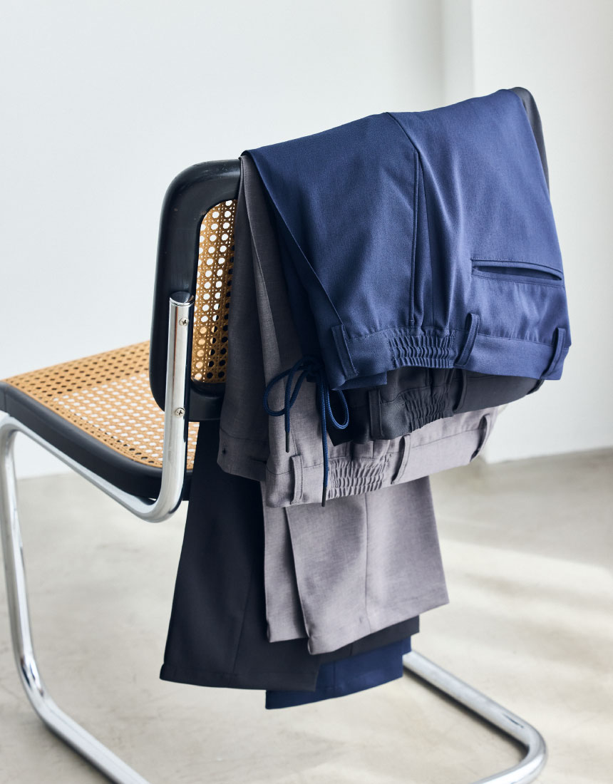 椅子に置かれているライトブラウンのスーツパンツ・ネイビーのスーツパンツ