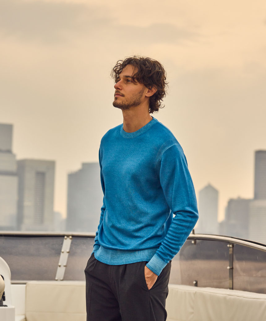 ブルーのトップス・ブラックのパンツを着用した男性