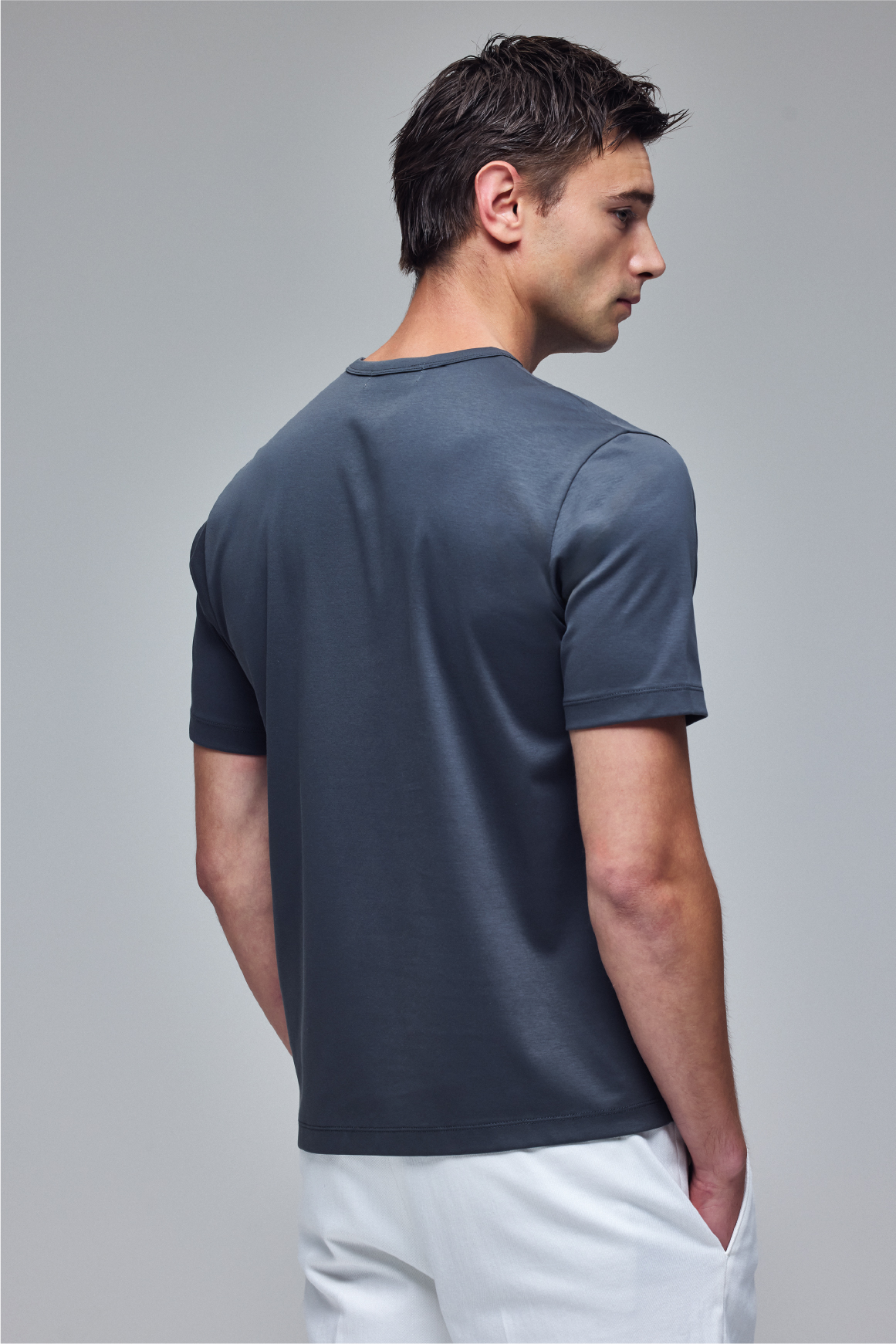 グレーのA PACK MULTI FUNCTION T-SHを着用した男性