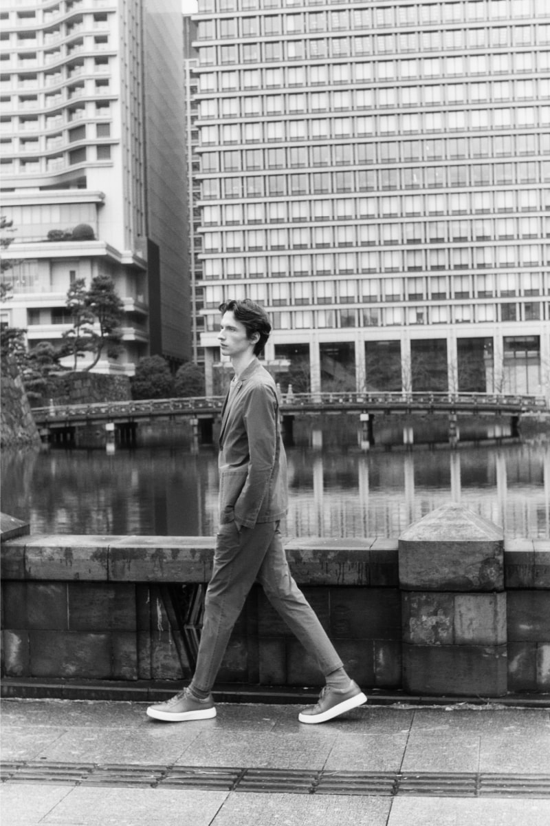 スーツを着た男性が街中を歩いているモノクロ画像