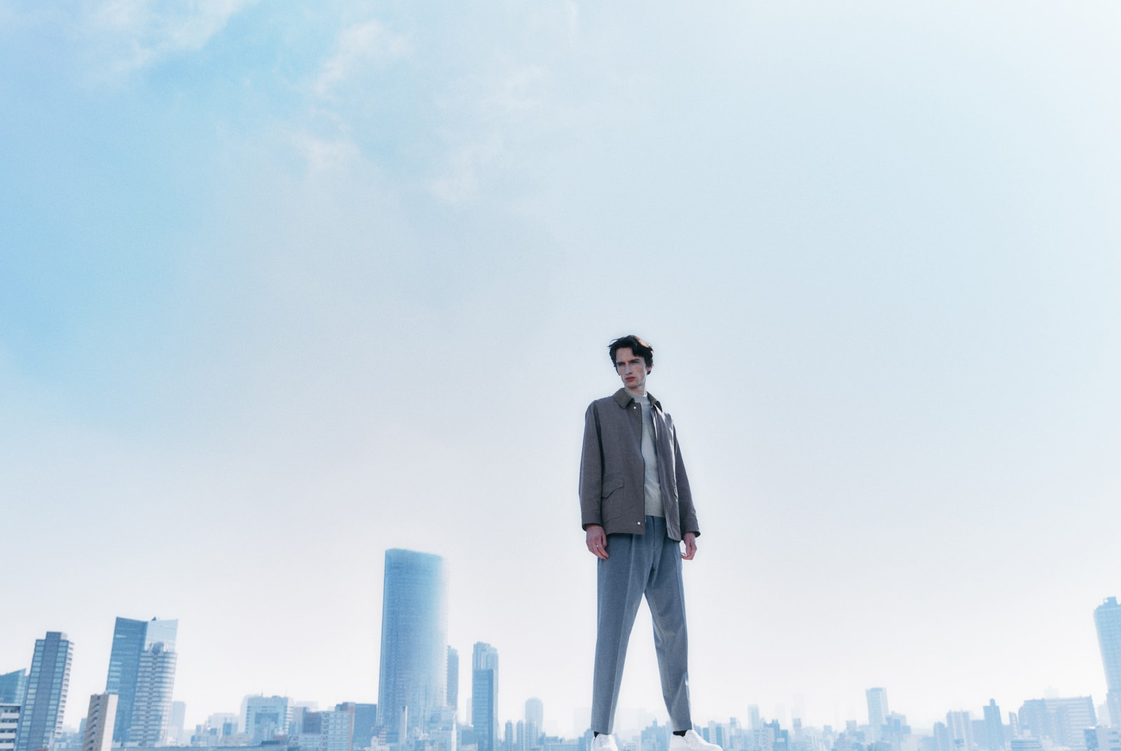 ブラウンのアウターを着た男性が左を向いている画像