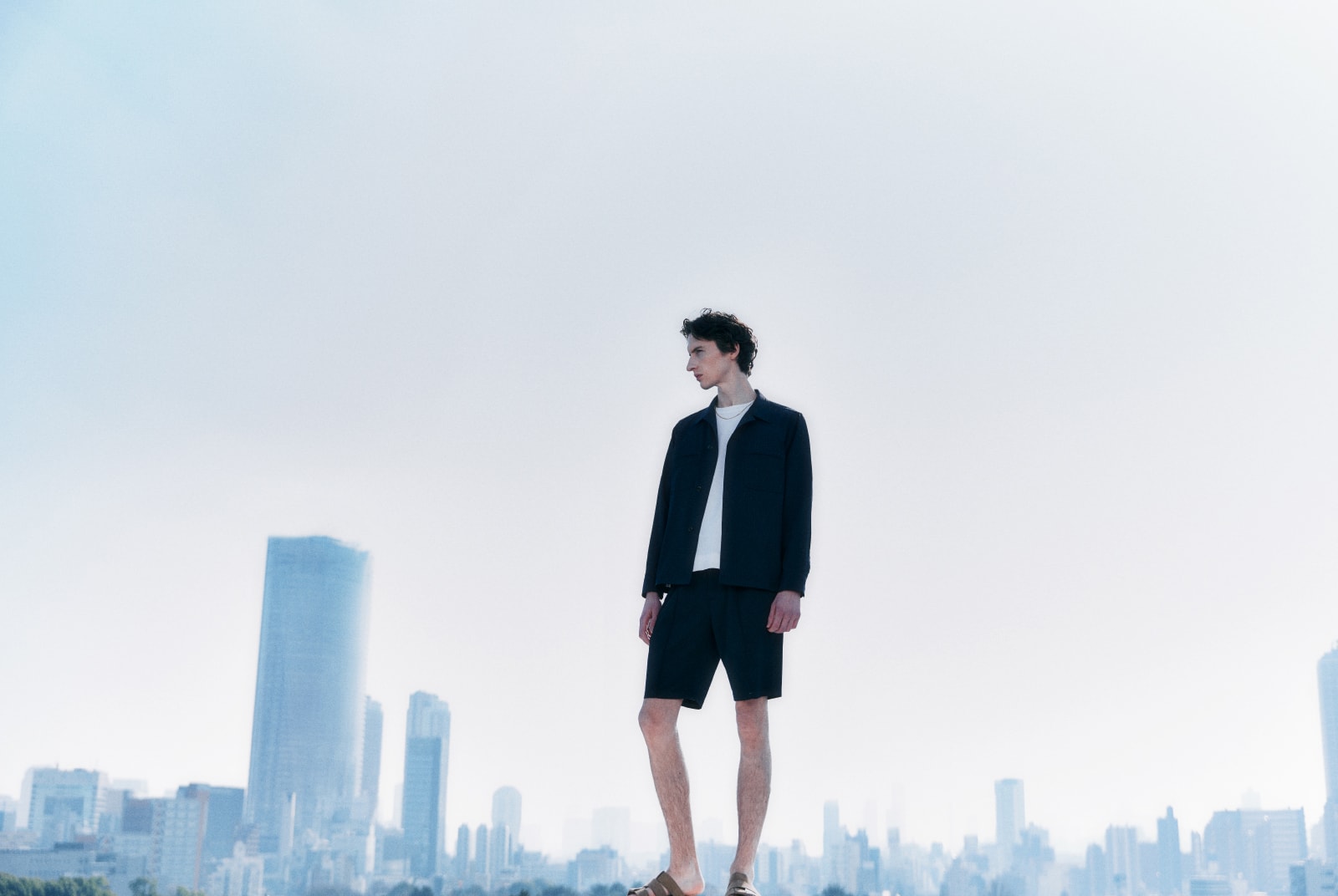 黒のセットアップを着た男性が左を向いている画像