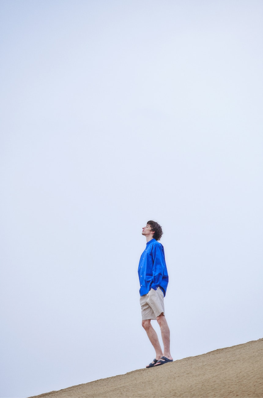 砂漠の上の男性が空を見上げている画像